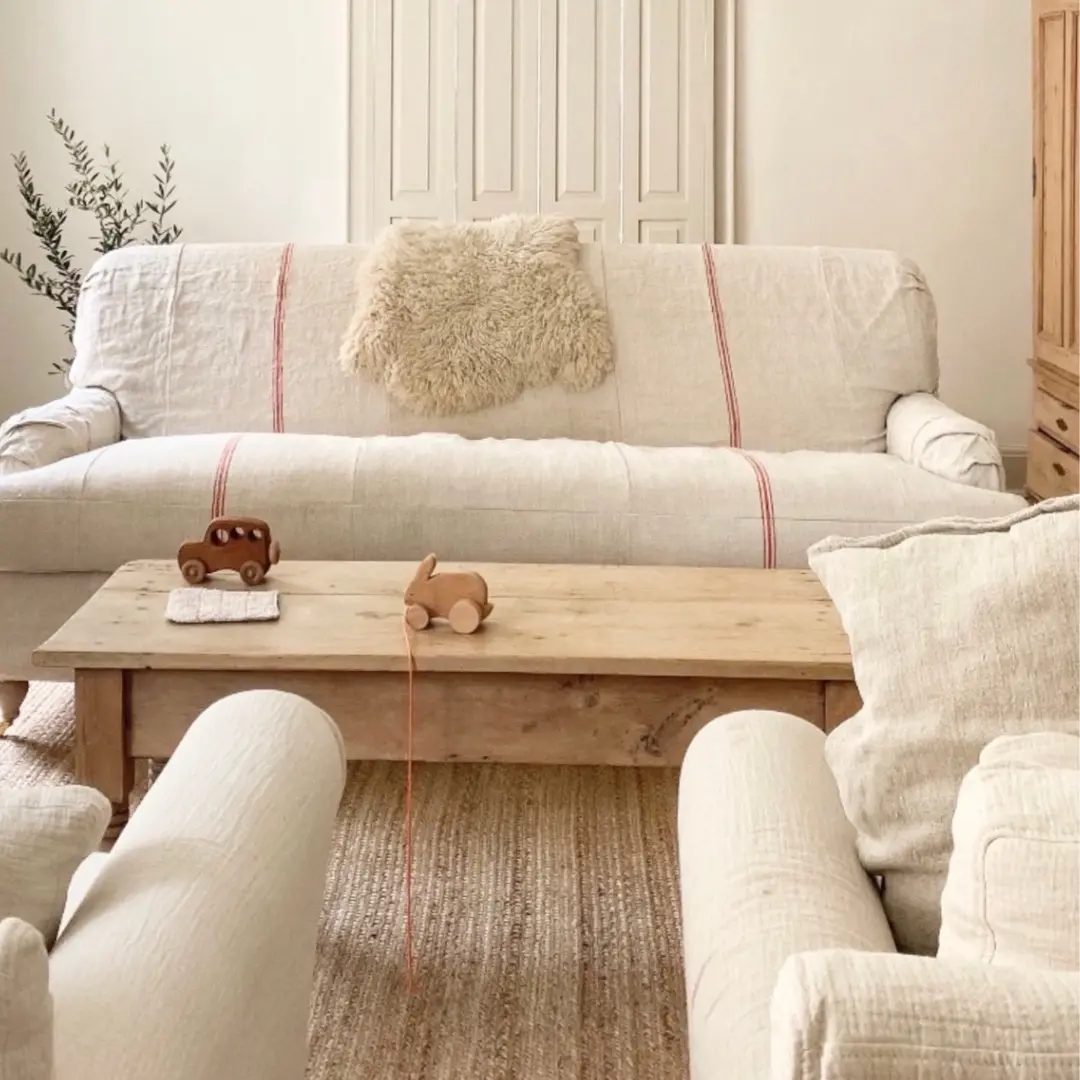A cozy white English Roll arm sofa with a light fabric