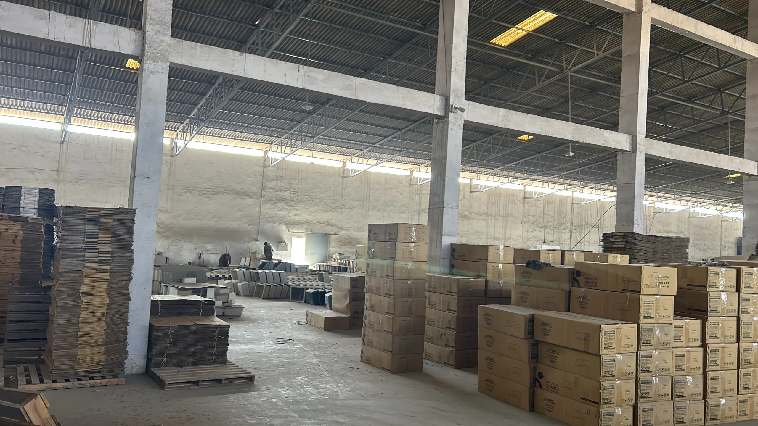 Multiple quartz kitchen sinks stacked in a manufacturing facility, showcasing Dinora’s large-scale production capabilities and precision in sink manufacturing for global distribution