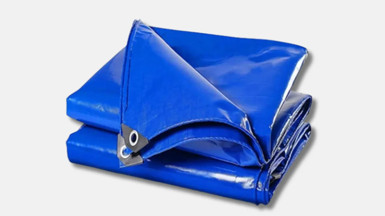 Folded blue custom tarpaulin with metal eyelets, tailored by leading tarpaulin supplier in India to meet specific size, color, branding, and thickness requirements for industrial and commercial use