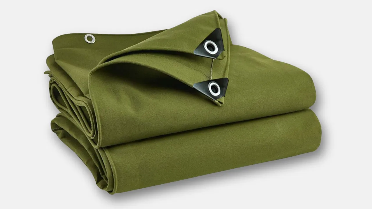 Folded olive green canvas tarpaulin with reinforced eyelets, produced by leading tarpaulin manufacturer in India, offering breathable, eco-friendly covers for tents, cargo, and warehouse protection