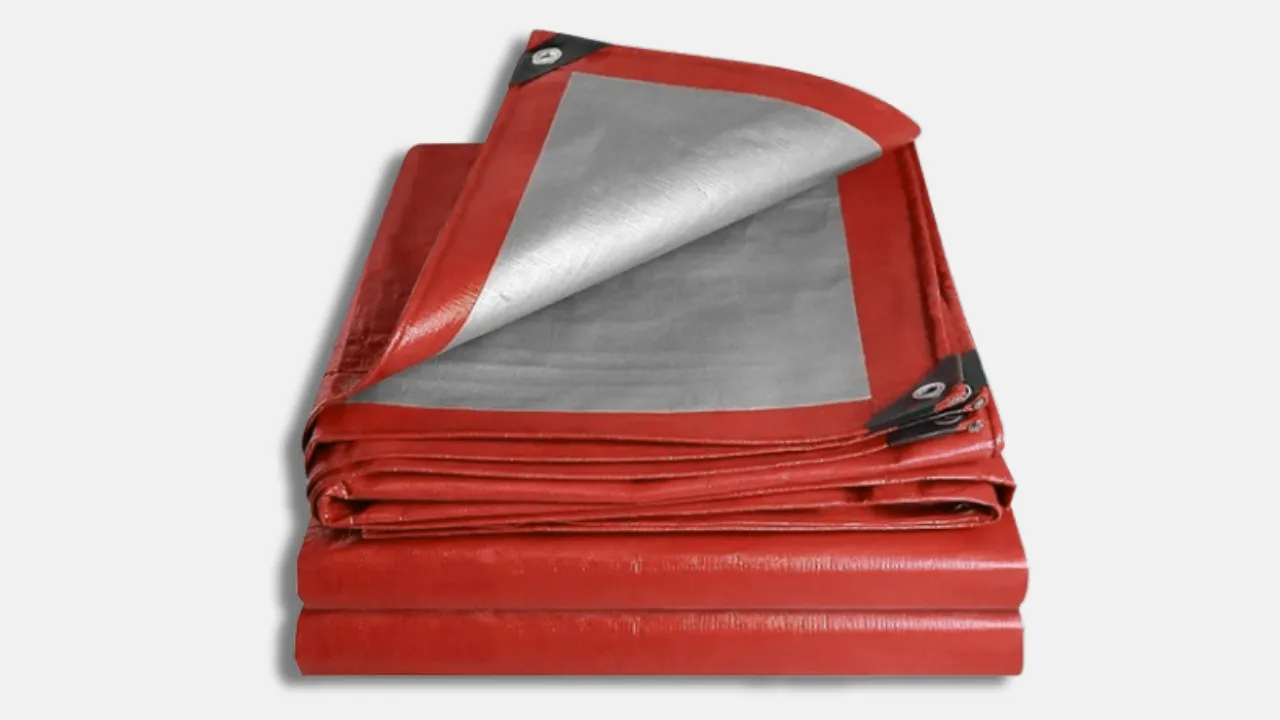 Folded red UV-stabilised HDPE tarpaulin with reinforced corners, designed for sun protection in agriculture, scaffolding, and outdoor storage, by leading HDPE tarpaulin manufacturer in India