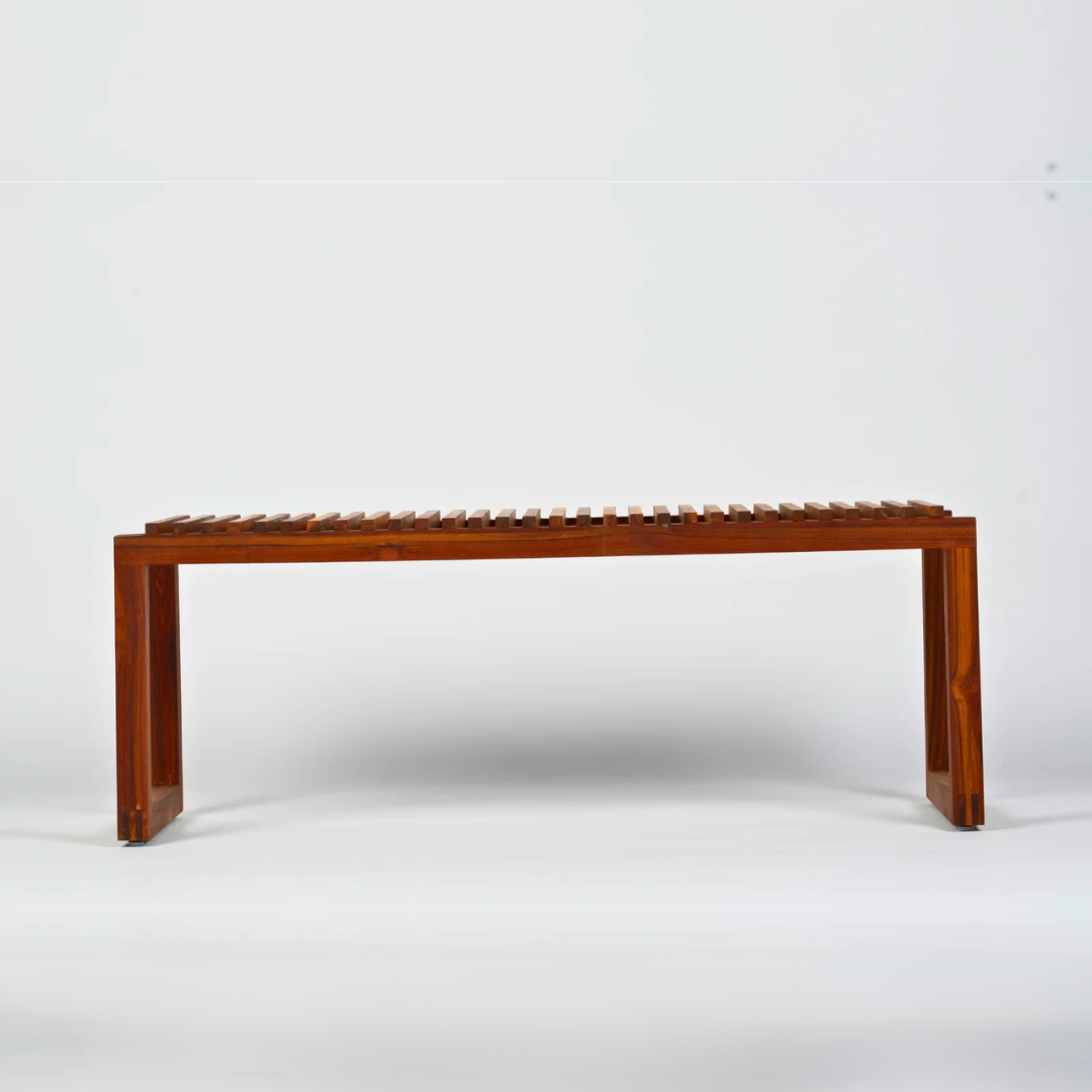 A minimalist reclaimed wood bench with a slatted design, showcasing clean lines and a natural wood finish. The sturdy construction ensures durability, making it ideal for high-traffic spaces such as cafes and dining areas. The bench's simple yet elegant design adds a natural and welcoming touch to any environment.
