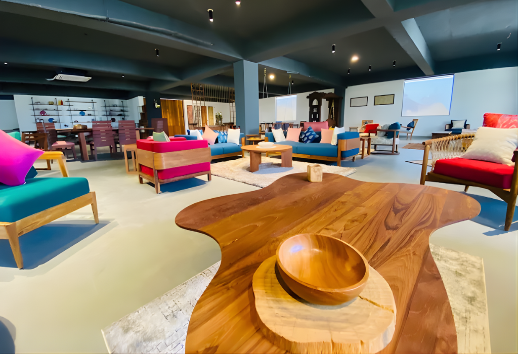 Spacious showroom featuring reclaimed teak wood furniture including handcrafted solid wood sofas, chairs, and a natural live edge teak coffee table built for long-lasting durability