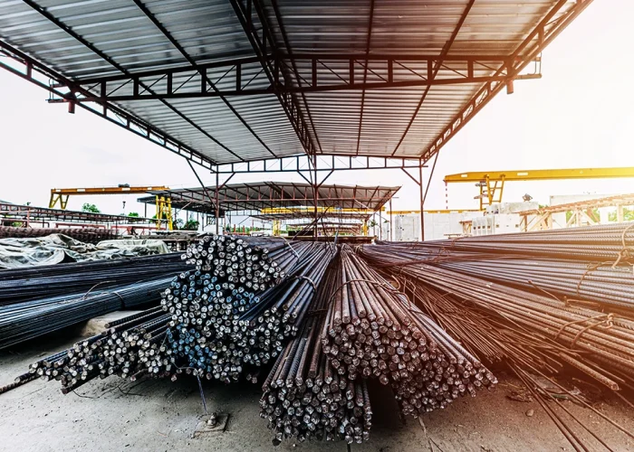 Bundles of stainless steel bars stored in a large industrial facility, showcasing strong in-house manufacturing capabilities of a stainless steel bar manufacturer with organized production and material handling setup.